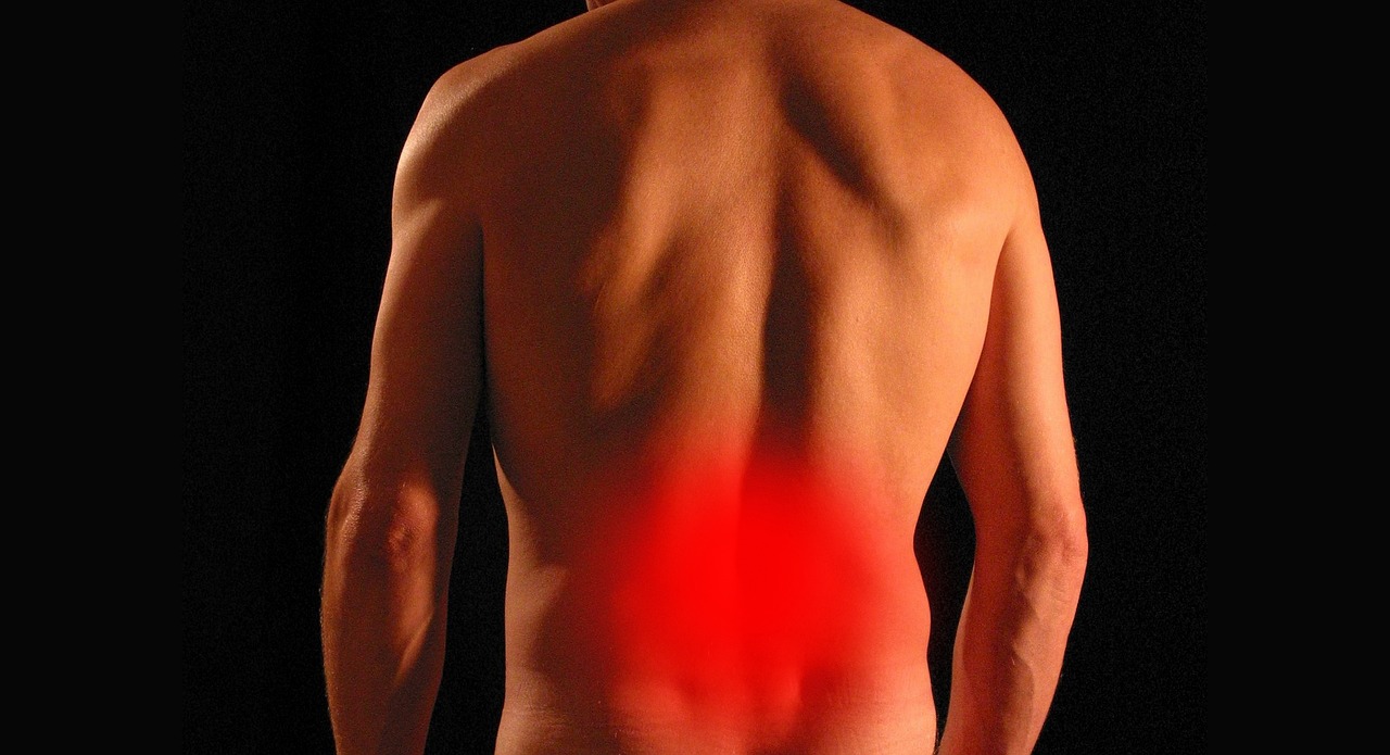Man's lower back with the painful area highlighted in red