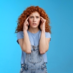 Woman pressing her fingers to her temples with a headache