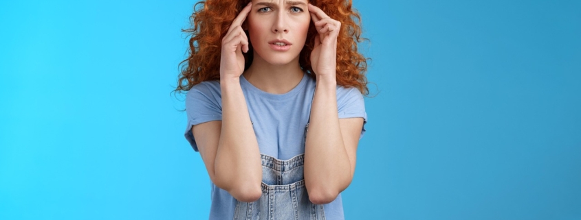 Woman pressing her fingers to her temples with a headache