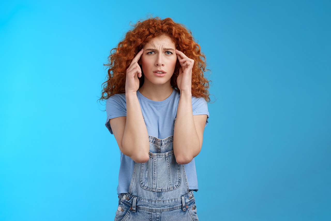 Woman pressing her fingers to her temples with a headache