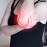 Woman holding her sore elbow