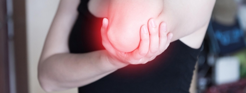 Woman holding her sore elbow